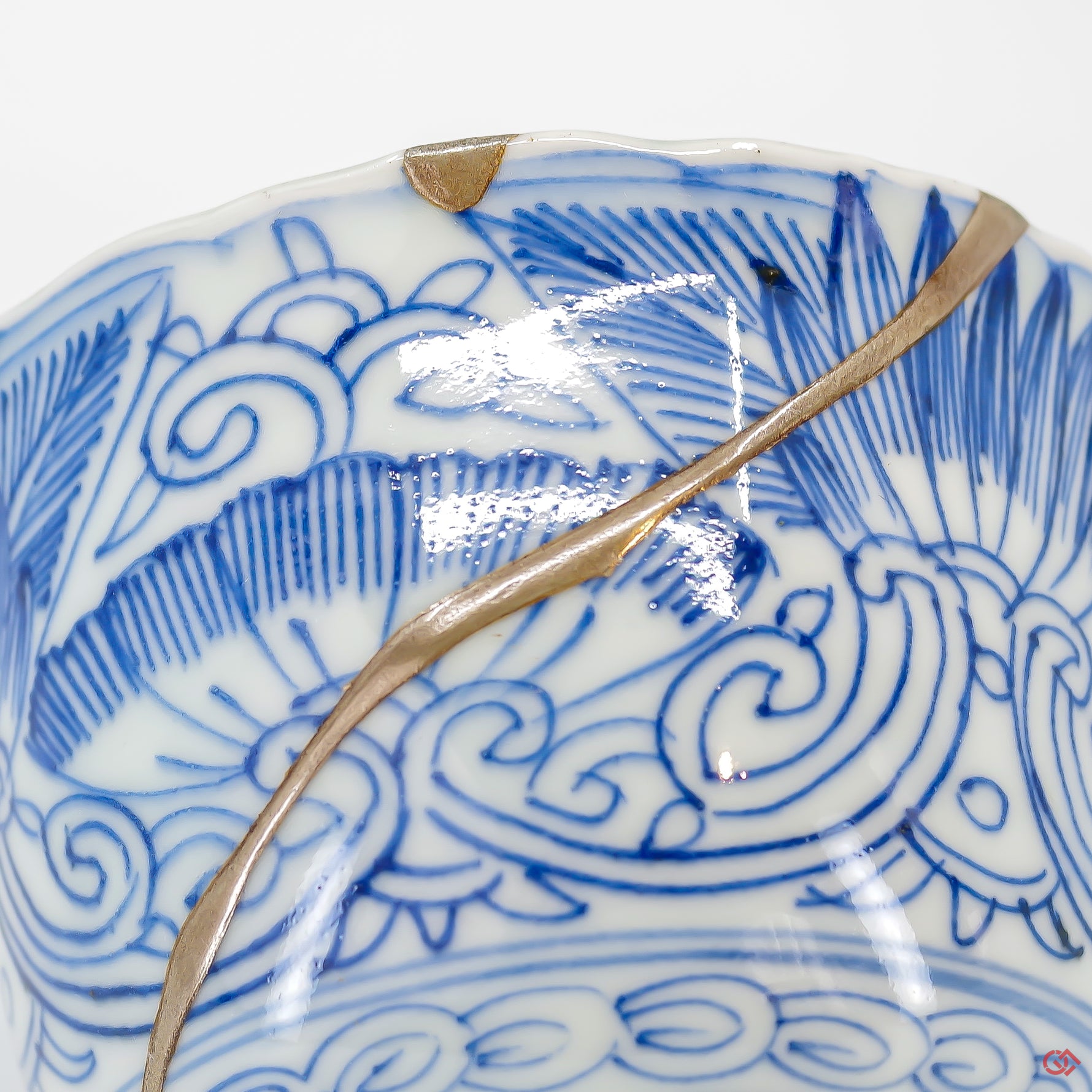 A close-up photo of an authentic Kintsugi pottery piece, showing the detail of its repairs and craftsmanship.