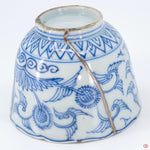 A close-up photo of an authentic Kintsugi pottery piece, showing the detail of its repairs and craftsmanship.