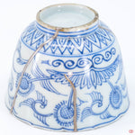 A close-up photo of an authentic Kintsugi pottery piece, showing the detail of its repairs and craftsmanship.