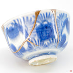 A close-up photo of an authentic Kintsugi pottery piece, showing the detail of its repairs and artisty. craftsmanship.