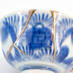 A close-up photo of an authentic Kintsugi pottery piece, showing the detail of its repairs and artisty. craftsmanship.