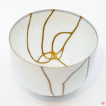 Close-up photo of an authentic Kintsugi pottery piece, showing the detail of its repairs and craftsmanship