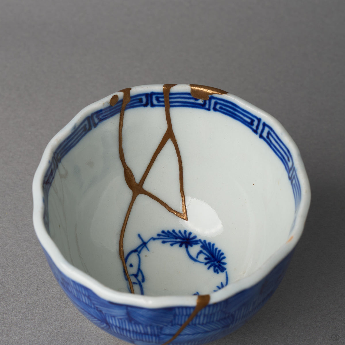 Kintsugi sake cup in Ko-Imari porcelain, rejoined with natural urushi, the 24K gold seam parting and meeting again beside the mikomi motif, interior close-up.