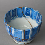 Kintsugi sake cup in Ko-Imari porcelain, rejoined with natural urushi, one 24K gold seam running from the rim down the inner wall into the well, interior view.