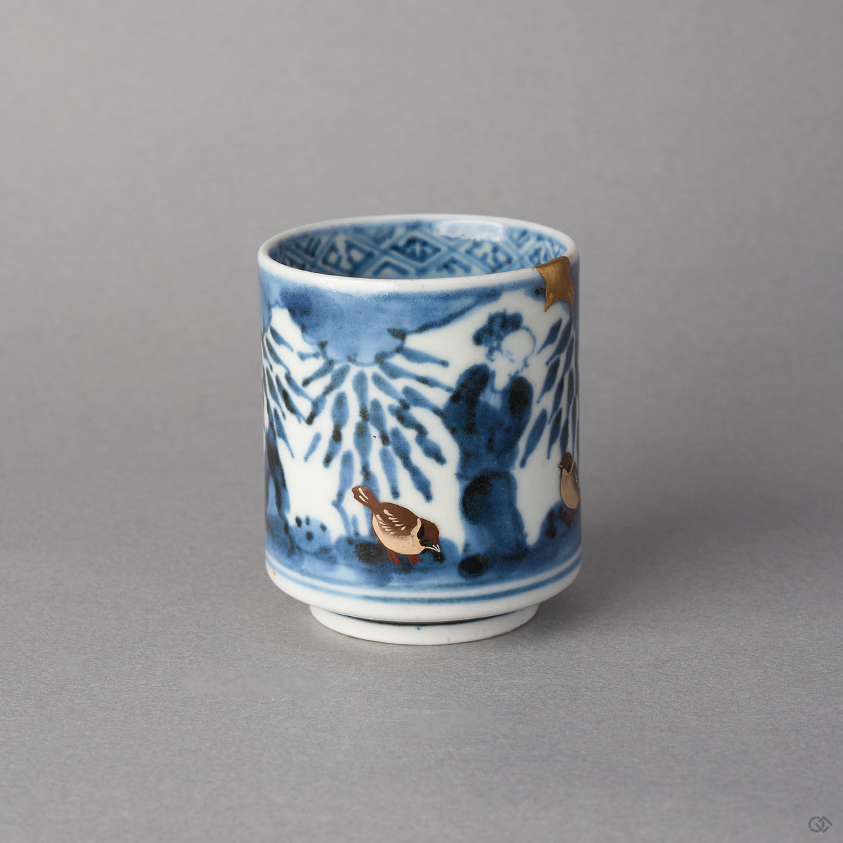 Kintsugi sake cup in Ko-Imari porcelain from the side, two urushi-e sparrows beneath the cobalt bamboo, the natural urushi and 24K gold rim at the edge.