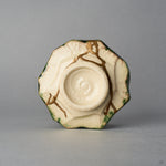 Kintsugi sake cup in Oribe ware seen from below, natural urushi and 24K gold seams crossing the unglazed base toward the foot ring, bottom view.