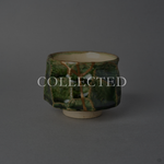 Kintsugi sake cup in faceted Oribe green pottery with an ivory well, restored with natural urushi and 24K gold, front view. Collected.