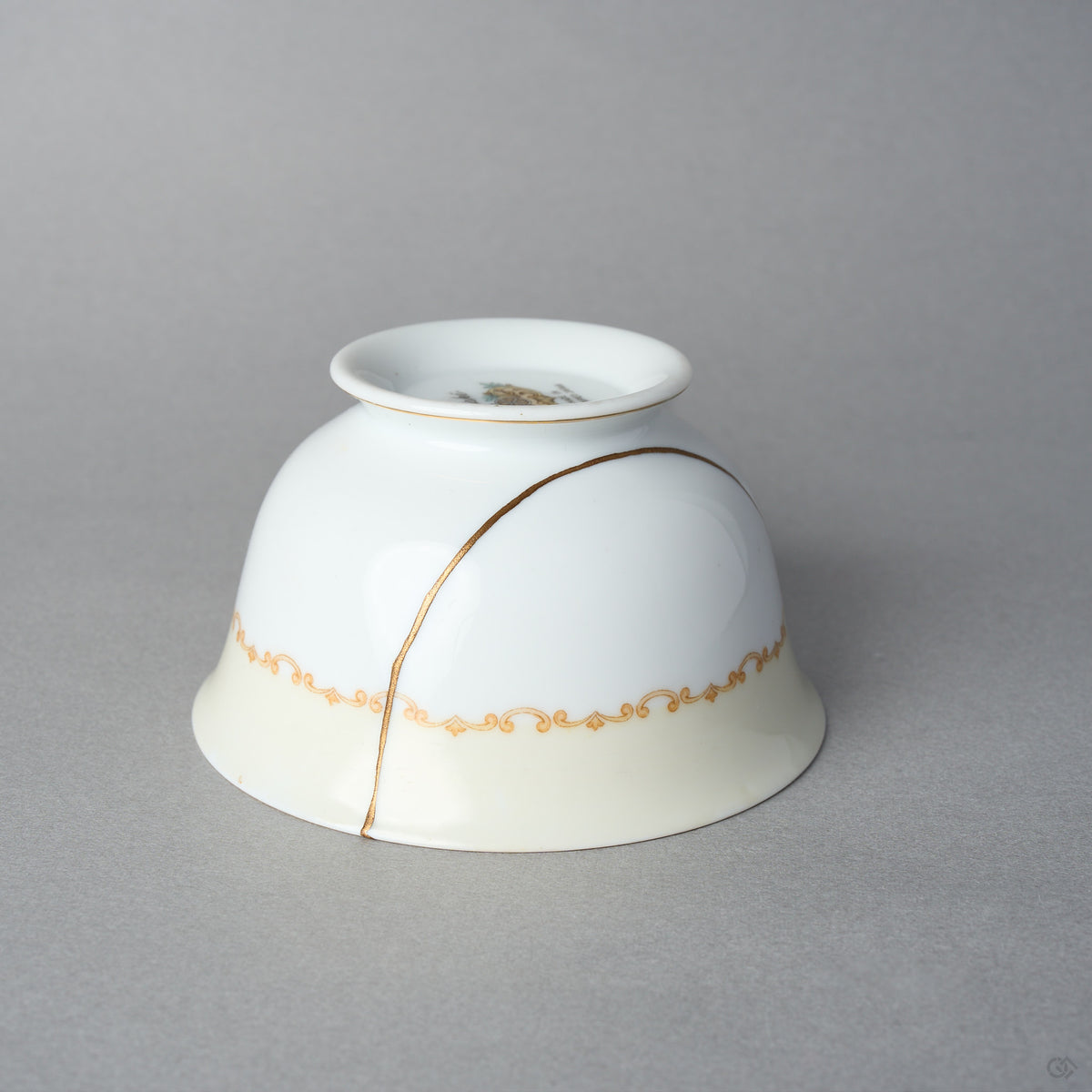 Kintsugi tea cup in Early Noritake porcelain, inverted side view: the 24K gold line in natural urushi arcs over the body and the gilt scroll band.