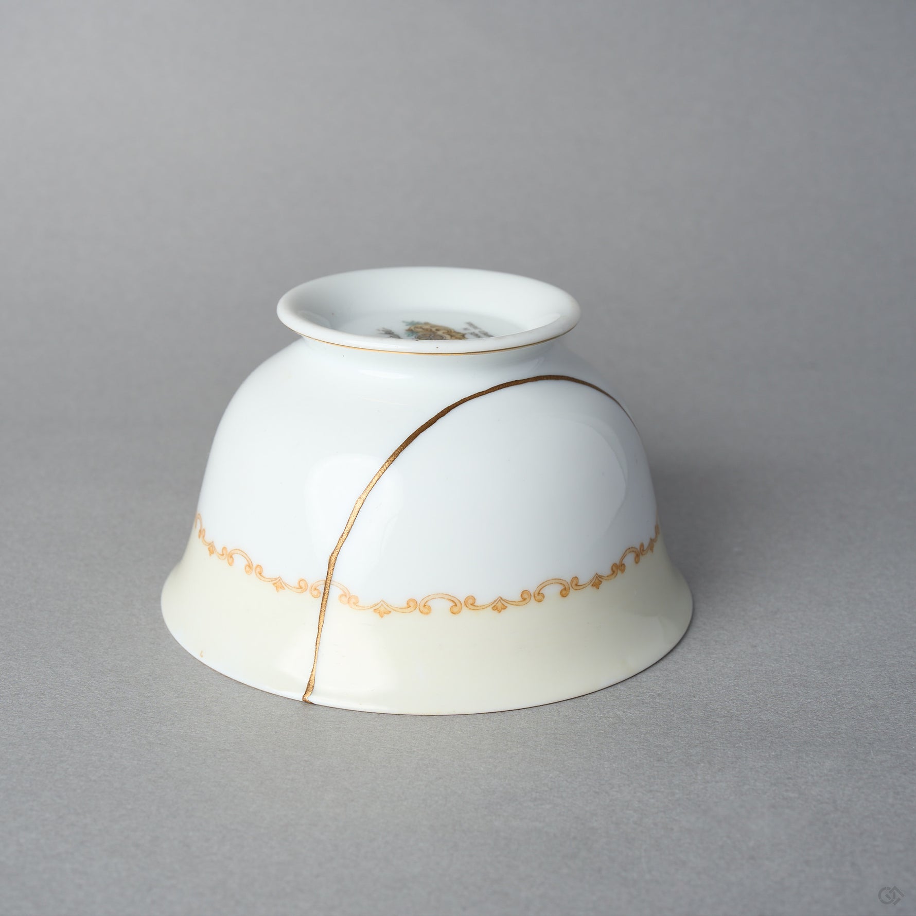 Kintsugi tea cup in Early Noritake porcelain, inverted side view: the 24K gold line in natural urushi arcs over the body and the gilt scroll band.