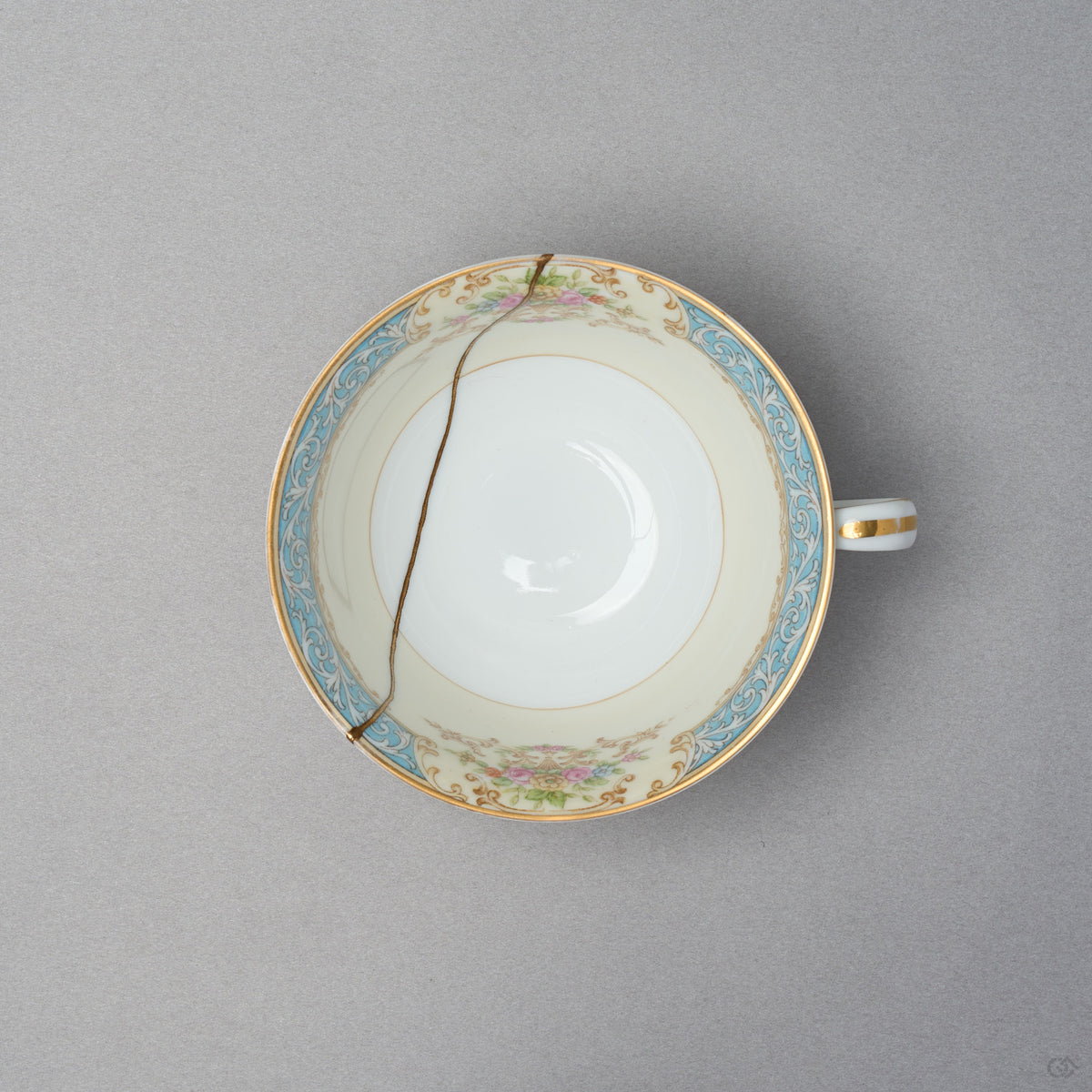 Kintsugi tea cup in Early Noritake porcelain, seen from above: a single 24K gold line in natural urushi crosses the interior well from rim to rim.
