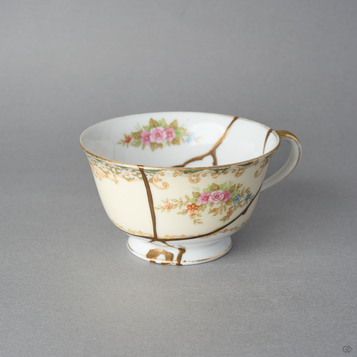 Kintsugi tea cup in cream Early Noritake porcelain, three natural urushi and 24K gold lines descending past the painted roses to meet at the foot, front view.