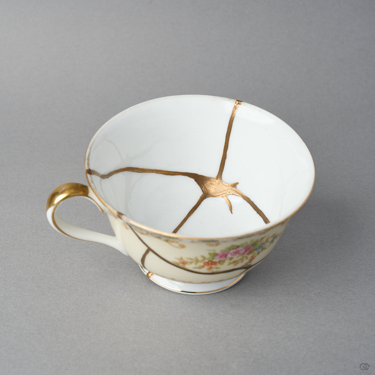 Kintsugi tea cup interior in Early Noritake porcelain, natural urushi and 24K gold seams converging into a star at the center of the white well, close-up.