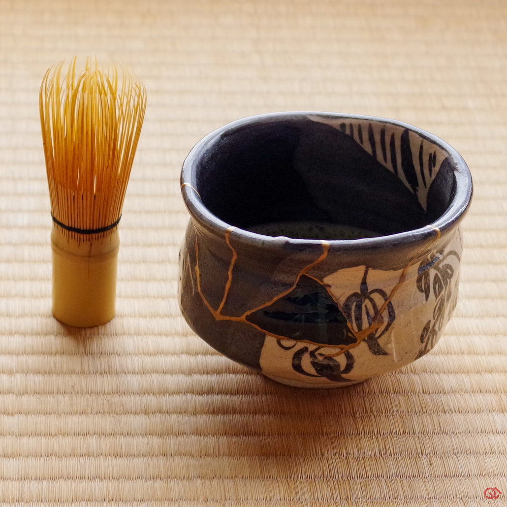 A photo of an authentic Kintsugi pottery piece being used in a real-world setting, such as a cup of matcha being poured into a Kintsugi teabowl.