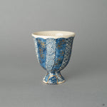A Kyoto ware sake cup, where 24k gold Kintsugi and a textured Kawari-nuri Seigaiha wave pattern exist in quiet harmony.