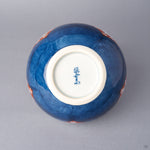 Base of an Arita ware lidded bowl in cobalt-blue porcelain with a white foot ring and a hand-painted cobalt kiln mark, showing the underside of the vessel.