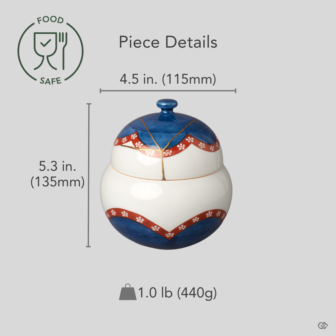 Arita ware lidded bowl in white porcelain with 24K gold kintsugi seams, restored with natural urushi, shown beside an object for scale reference.