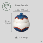Arita ware lidded bowl in white porcelain with 24K gold kintsugi seams, restored with natural urushi, shown beside an object for scale reference.