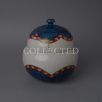 Arita ware lidded bowl in glossy white porcelain with a cobalt-blue crown and base, vermilion plum-blossom bands, and a 24K gold kintsugi seam over the domed lid, shown from the front. Sold out.