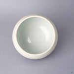 Top view of the body of an Arita ware lidded bowl in white porcelain with a pale celadon-toned glazed interior, glossy and undamaged, shown without the lid.