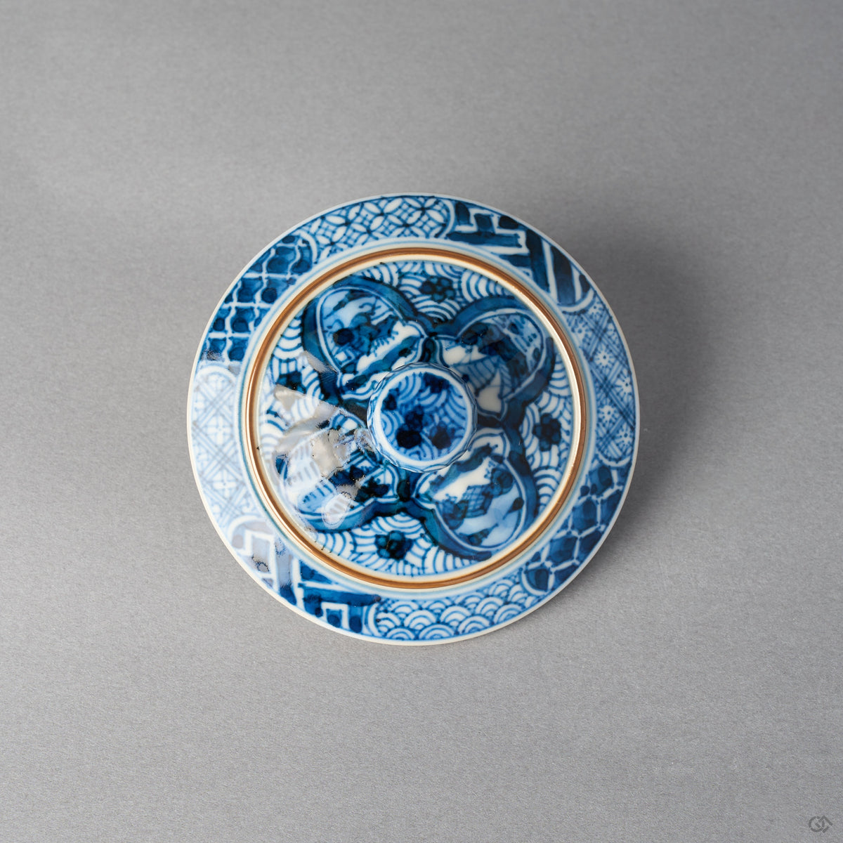 Top of the intact lid of the kintsugi lidded tea cup; its gold ring and lines are original gilt decoration, and no restoration is visible in this view.
