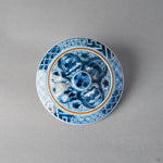Top of the intact lid of the kintsugi lidded tea cup; its gold ring and lines are original gilt decoration, and no restoration is visible in this view.