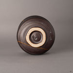 Bottom view of kintsugi Arita matcha bowl with unglazed foot ring and clay base, visible resilience in every restored edge.