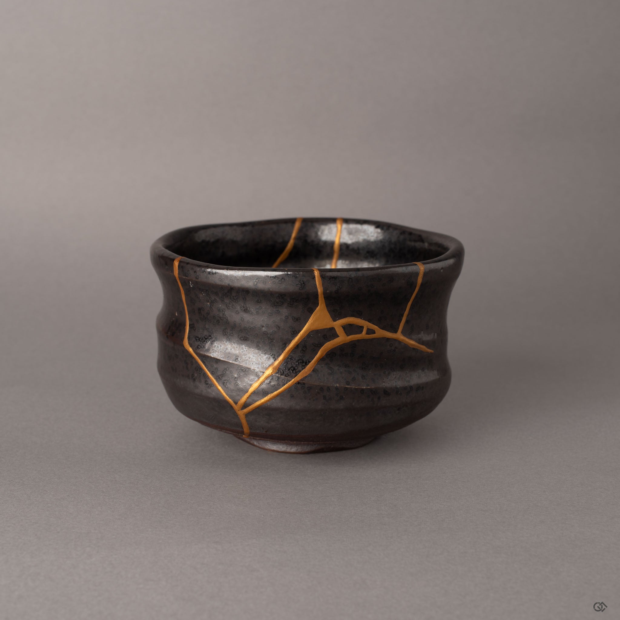 Kintsugi Arita matcha bowl in dark charcoal matte glaze with branching gold seams, a quiet presence rooted in Japanese porcelain tradition.
