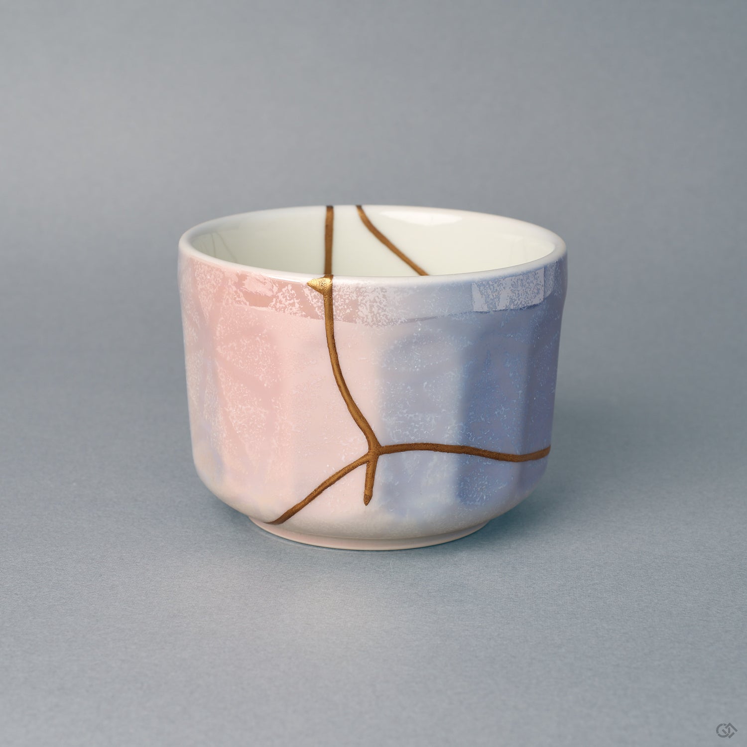 Kintsugi Arita matcha bowl seen from the front, gold seams crossing a pastel rose-to-blue glaze — a quiet beauty in porcelain.