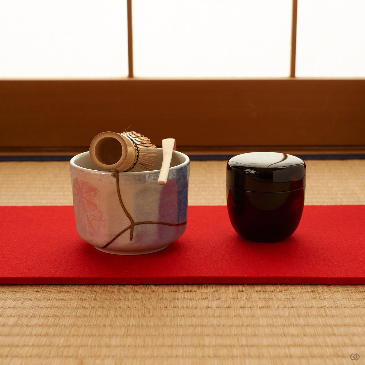 The kintsugi matcha bowl resting on tatami, its gold seams soft in daylight, a small note of intentional living in a tea setting.