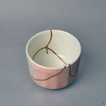 Close within the bowl, roiro-finished gold catches light along a kintsugi seam, hinting at the patina of time in urushi.
