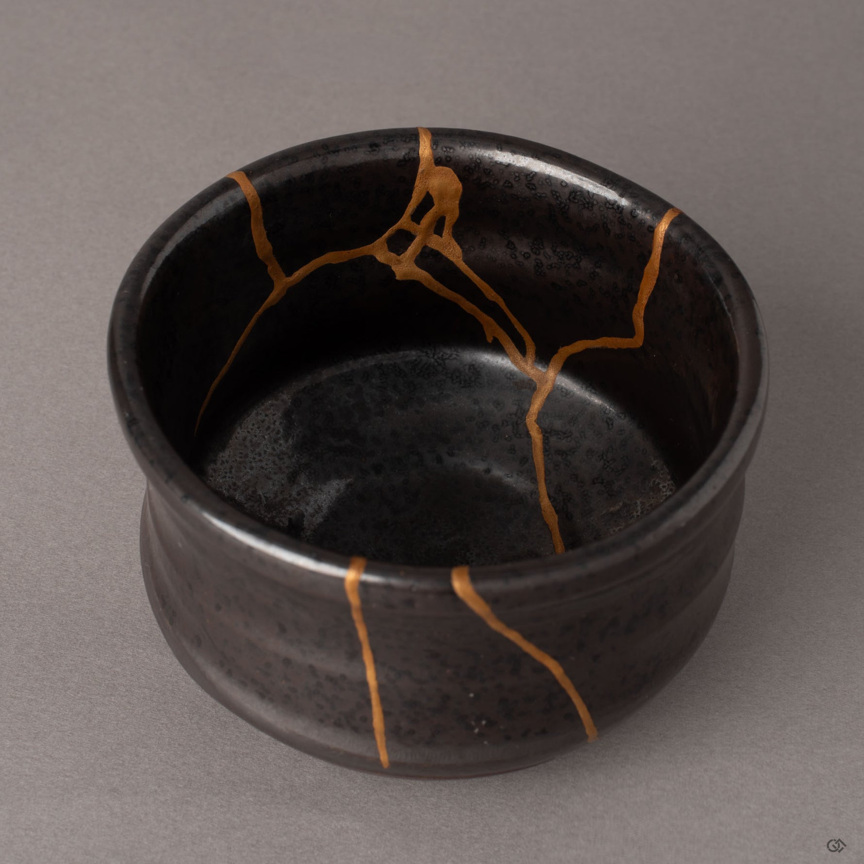 Interior close-up of kintsugi gold lines converging inside an Arita matcha bowl, natural urushi lacquer beneath the gold, a tactile history.