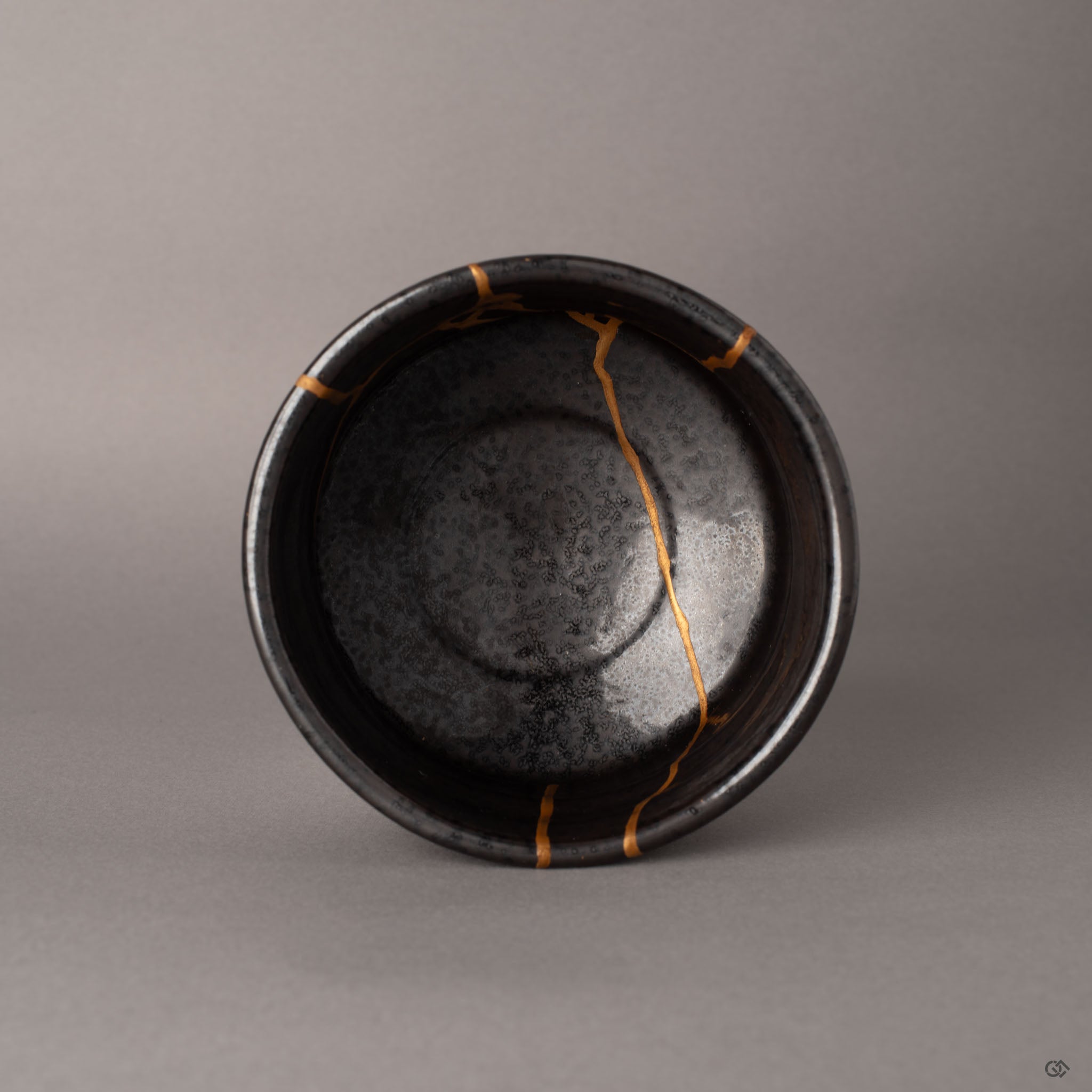Top view of kintsugi Arita matcha bowl showing the organic rim and gold seams spanning the dark interior, a philosophy in form.