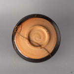 The foot ring of this Arita kintsugi bowl grounds the piece, dark glaze meeting bare clay, history made visible at the base.