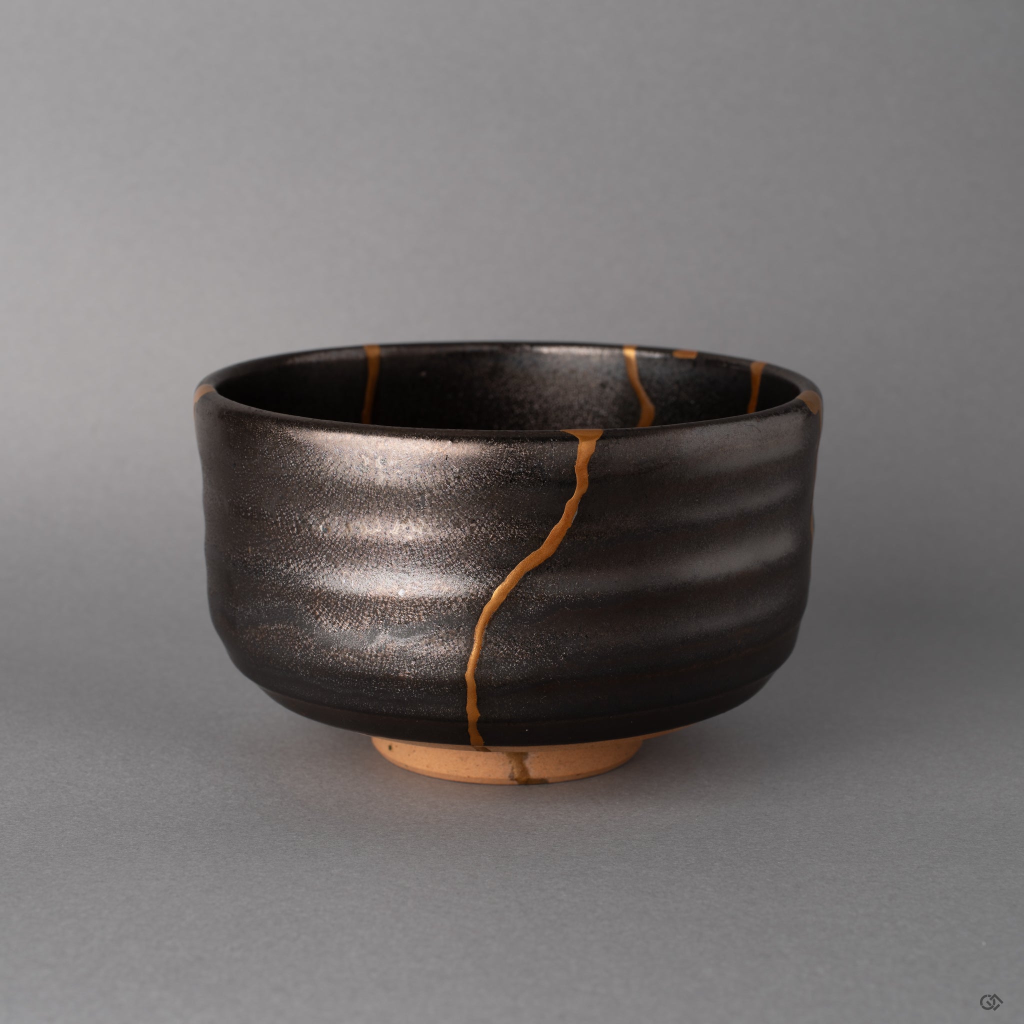 The gray glaze of this Arita matcha bowl deepens under soft light, kintsugi gold warm against its calm surface, slow craft visible.