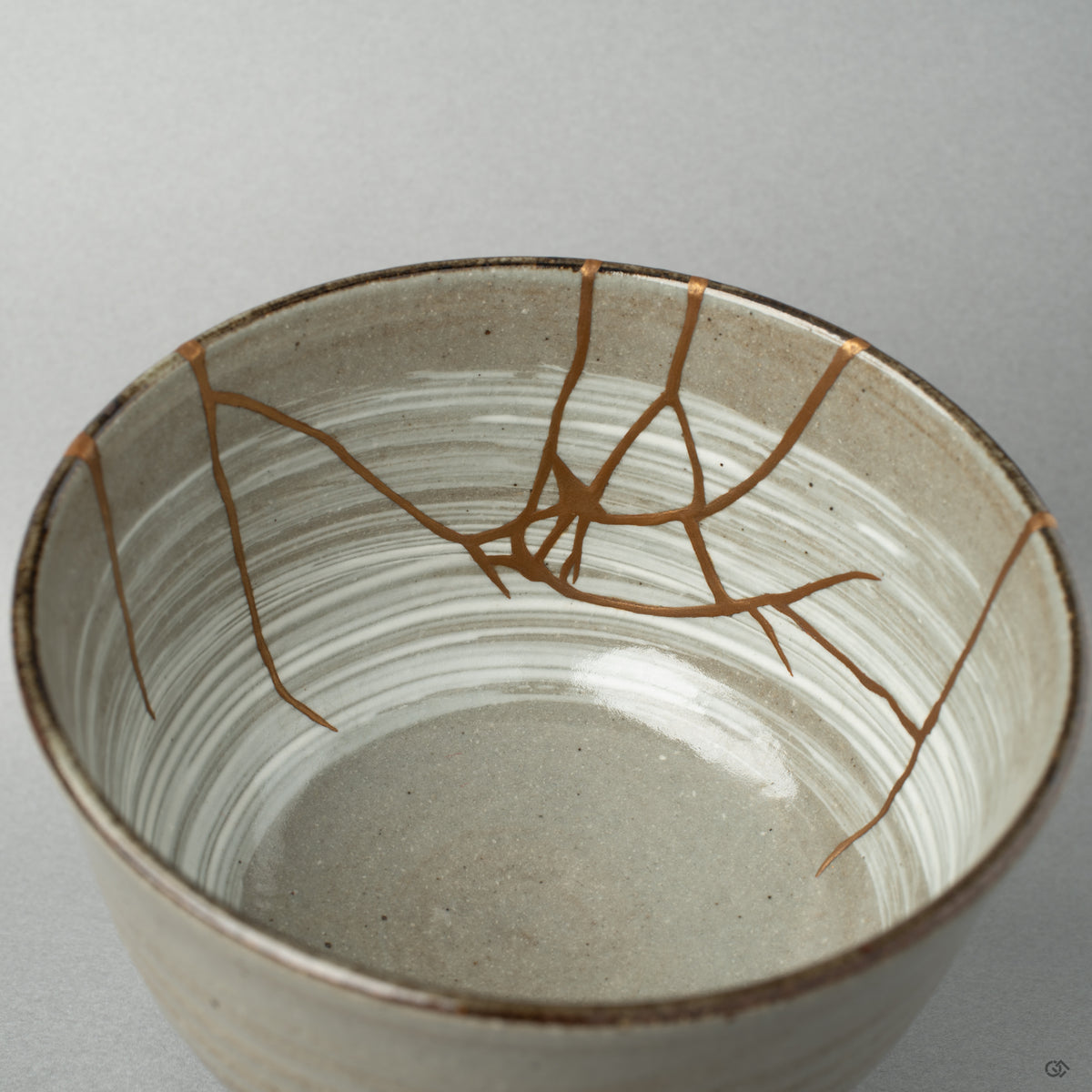 Close up on the interior kintsugi seam. The gold catches the light, giving the vessel a tangible piece of Japanese philosophy.