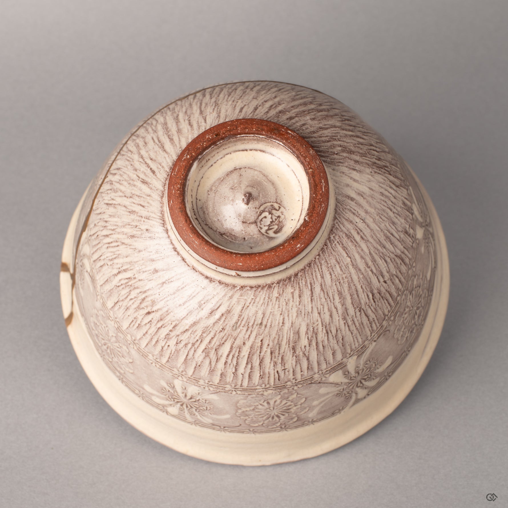 The foot ring of a Kyoto kintsugi bowl where purple glaze meets raw clay, history made visible in the foundation beneath.