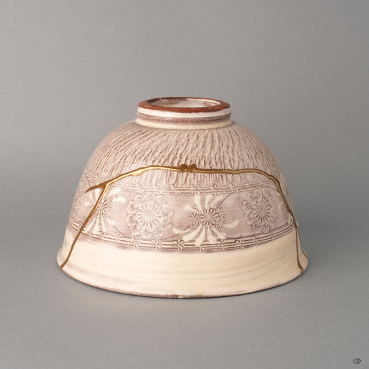 Profile of a purple Kyoto matcha bowl, gold kintsugi threads following its gentle curve, beauty in imperfection given form.