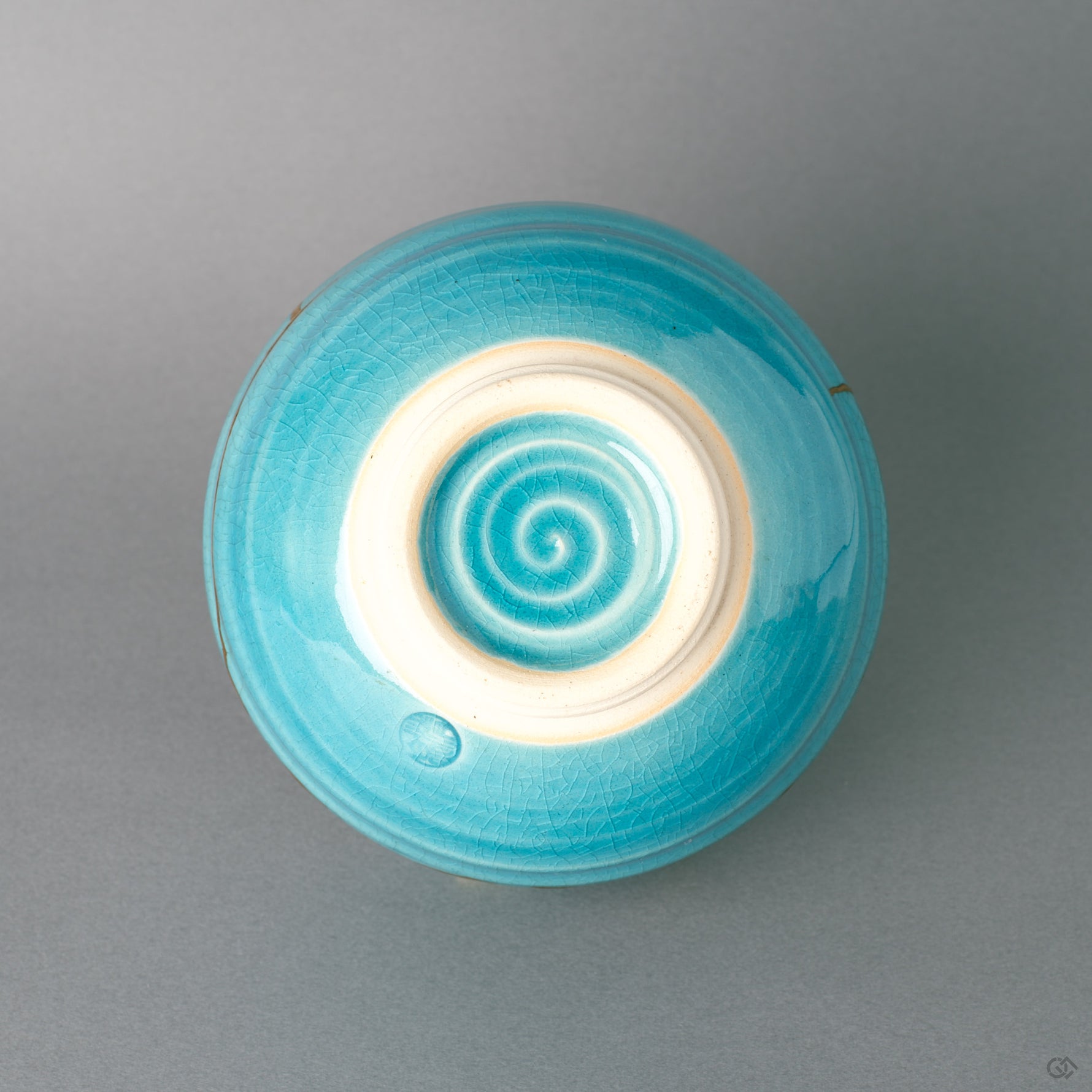 The unglazed foot of this kintsugi Kyoto bowl shows bare earthenware, tactile history beneath the turquoise glaze.
