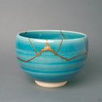 Kintsugi Kyoto matcha bowl in turquoise crackle glaze, gold seams crossing the front, wabi-sabi held in a single vessel.