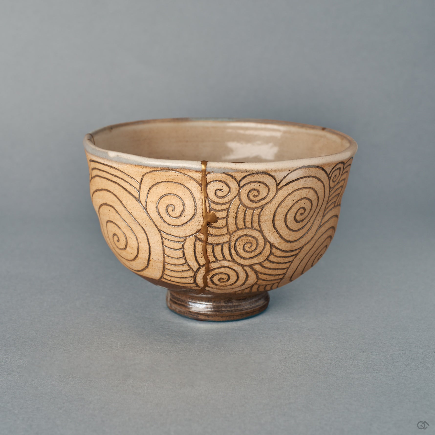 Front view of a kintsugi Kyoto matcha bowl, a single gold seam over carved spirals on warm clay, wabi-sabi quiet.