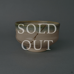 Sold out: kintsugi Kyoto Ware matcha bowl restored with 24K gold, a single gold seam descending an ivory body beneath a green glaze rim.
