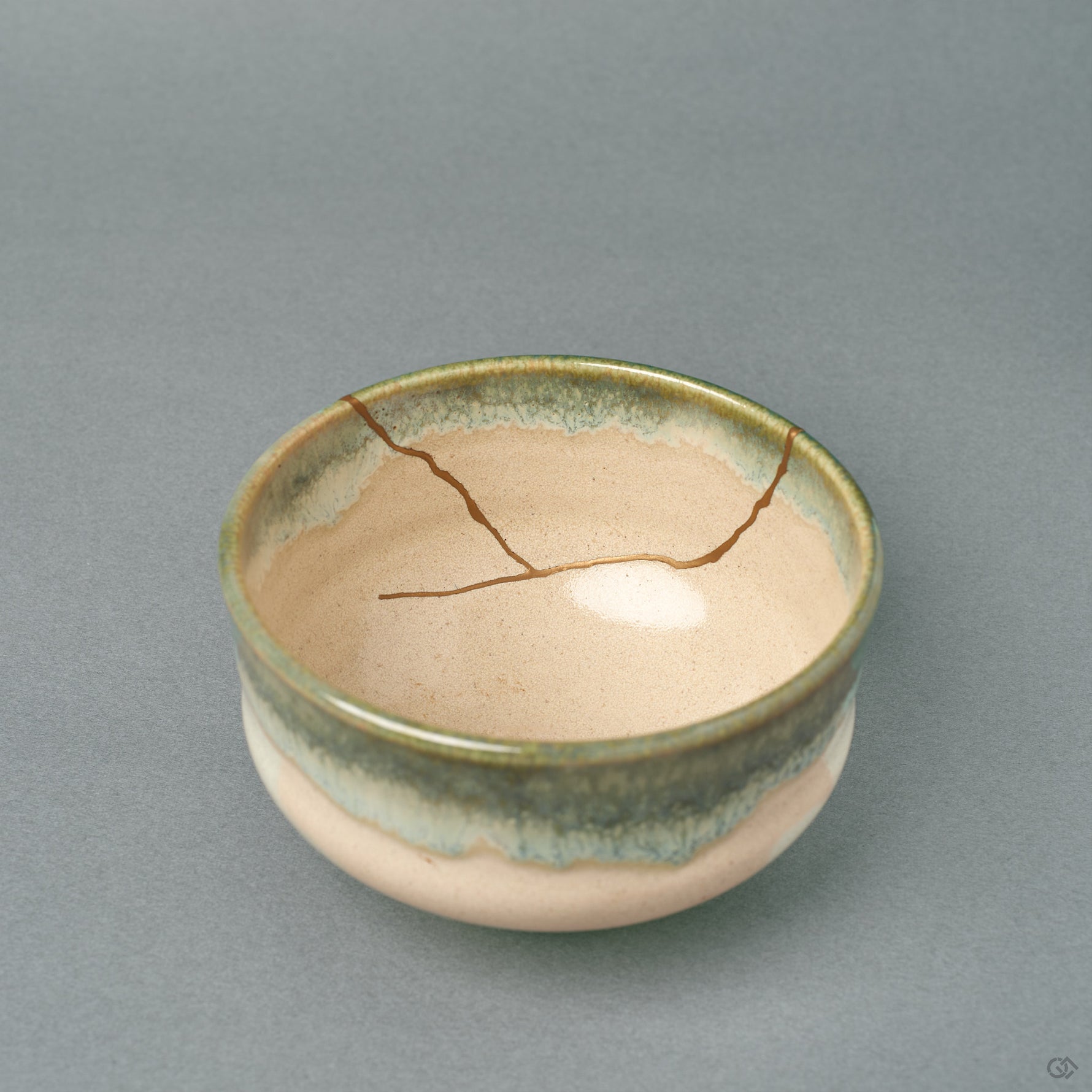 Looking into this kintsugi Kyoto matcha bowl, the glossy cream interior and green-rimmed glaze carry the patina of time.