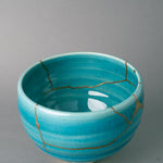 Looking into the bowl, gold kintsugi follows a break near the rim, the patina of time settling over turquoise.