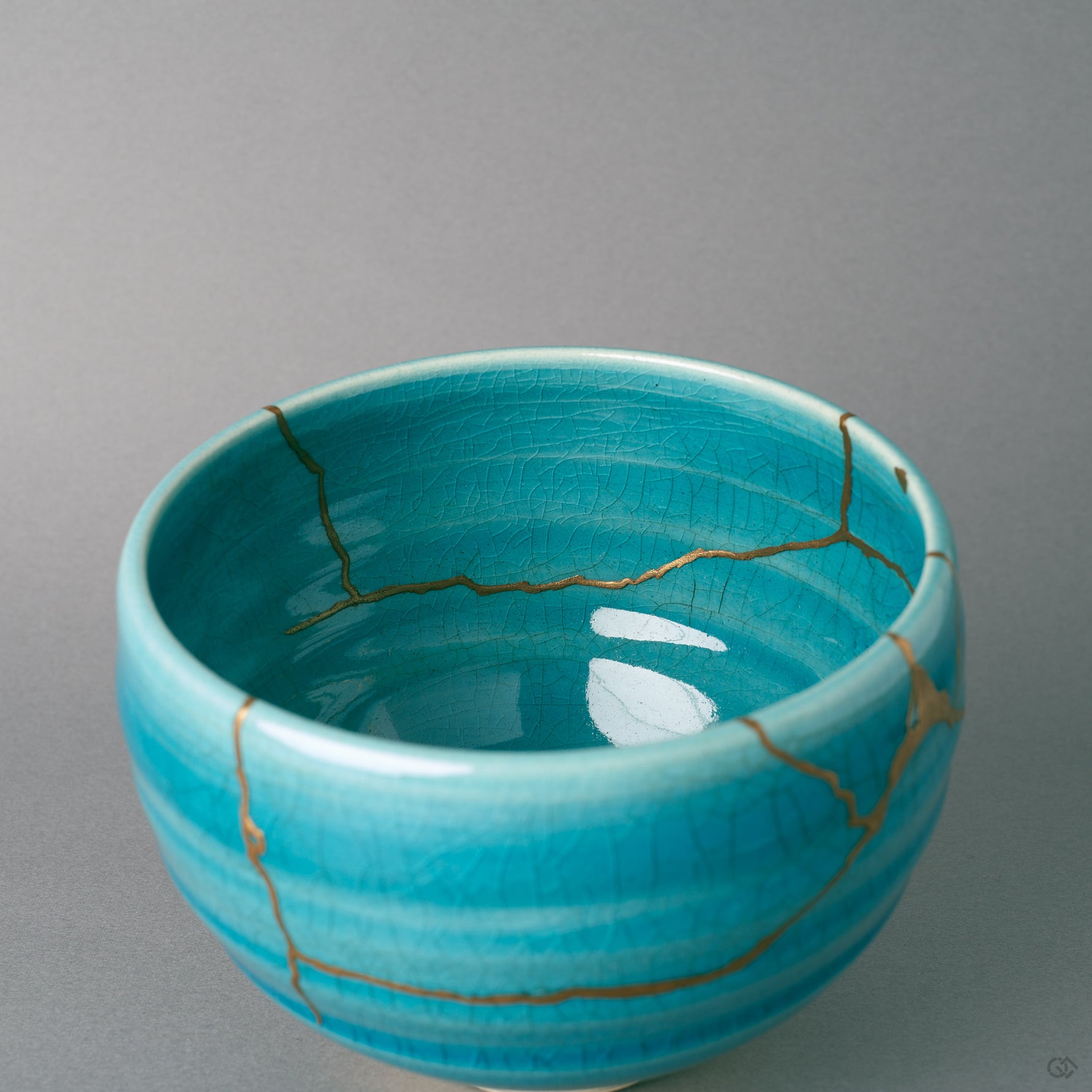 Looking into the bowl, gold kintsugi follows a break near the rim, the patina of time settling over turquoise.