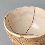 The interior rim of the kintsugi bowl, glaze and clay meeting at the lip, carrying a sense of tactile history.