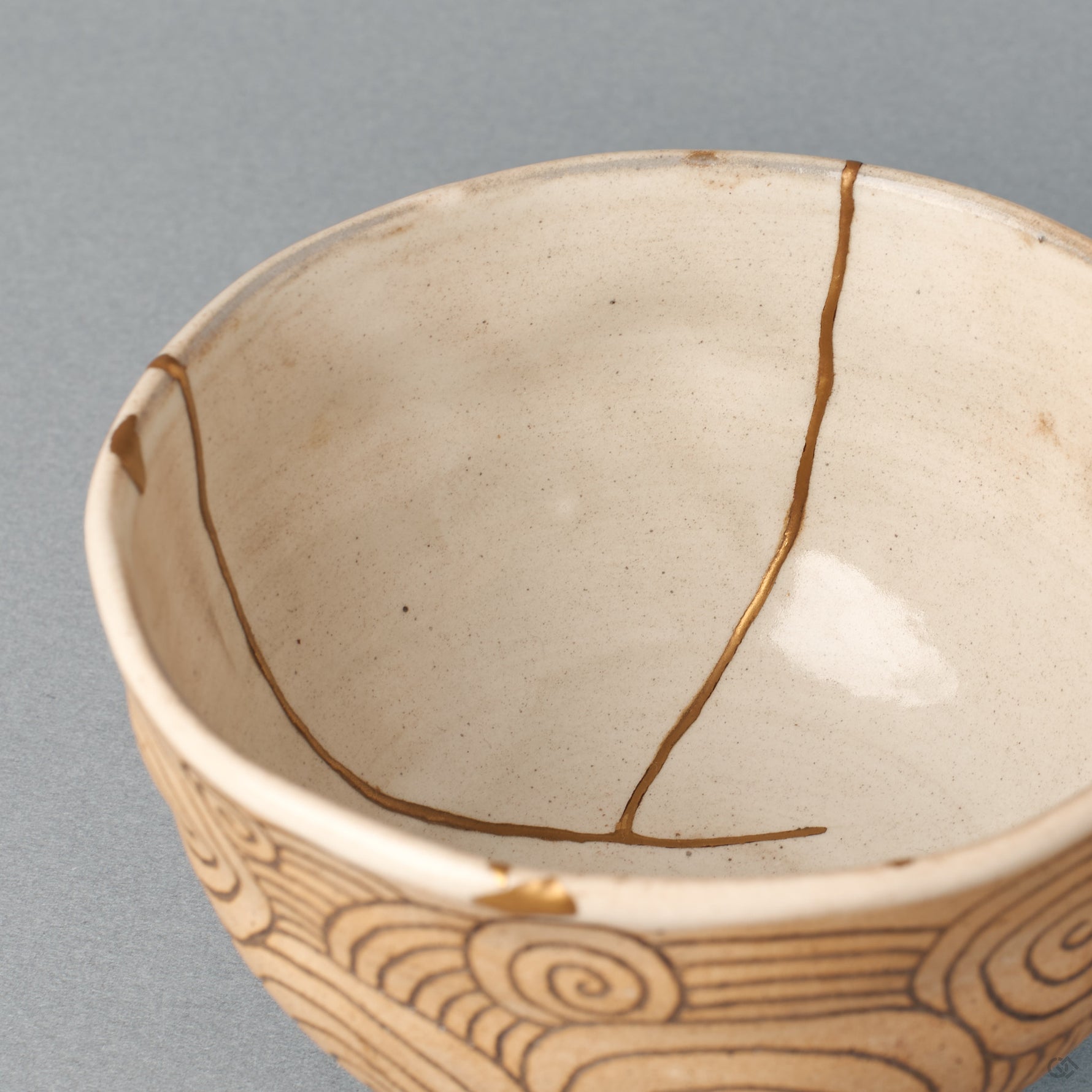 The interior rim of the kintsugi bowl, glaze and clay meeting at the lip, carrying a sense of tactile history.