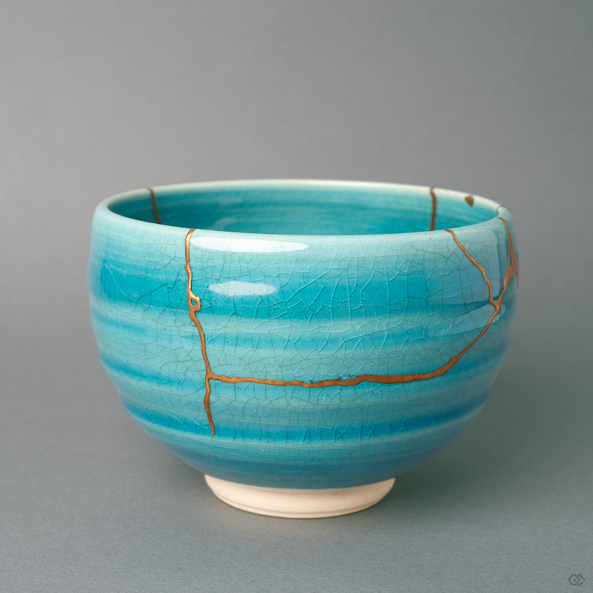 Seen from the side, this kintsugi bowl shows gold lines following the breaks across its turquoise body, a quiet beauty in every curve.