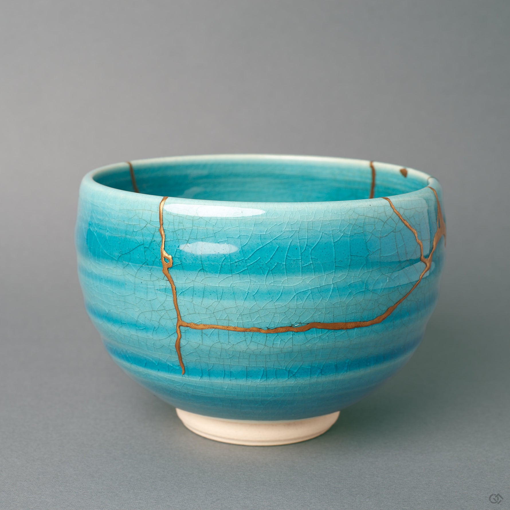 Seen from the side, this kintsugi bowl shows gold lines following the breaks across its turquoise body, a quiet beauty in every curve.