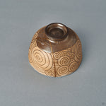 From another side, the kintsugi bowl reveals more carved spirals across its rounded form, Japanese craftsmanship in line.