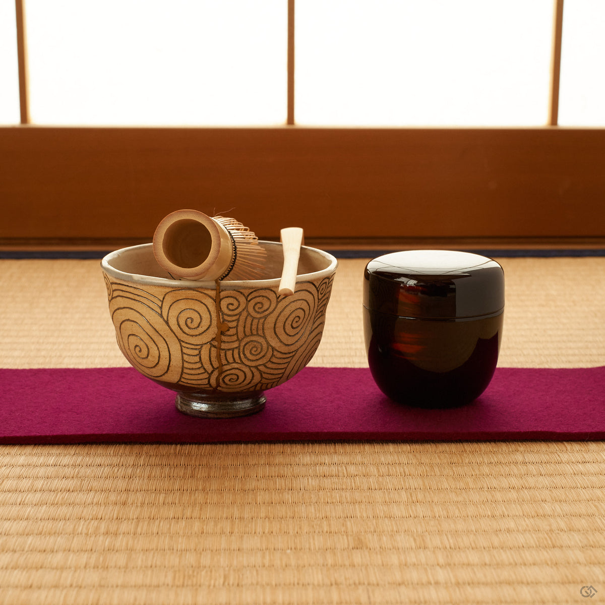 The kintsugi bowl rests on tatami in soft light, its gold seam catching a moment of contemplation.